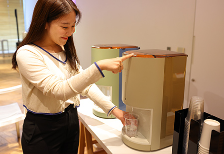 ウォーターサーバーからコップに水を注ぐ様子